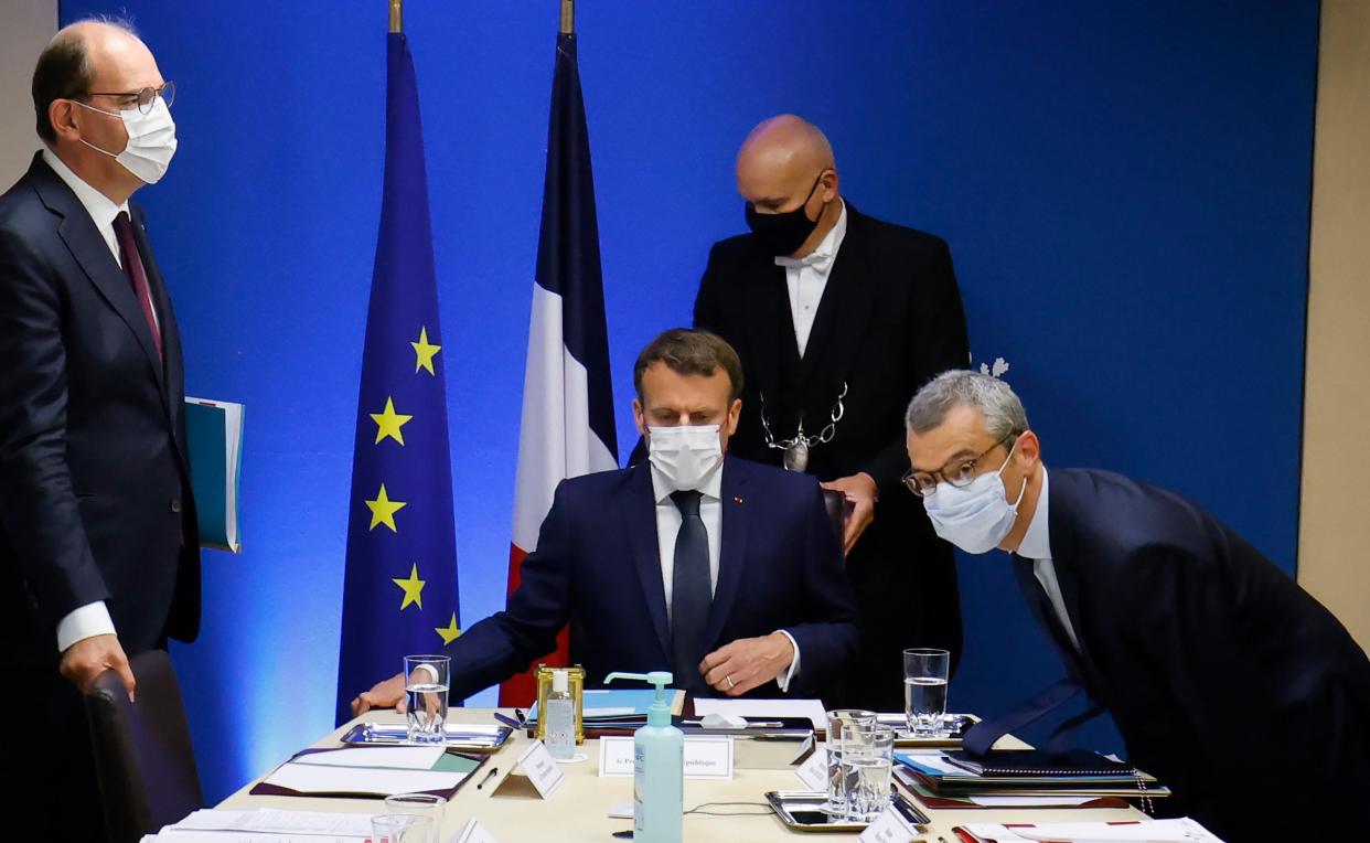 French President Emmanuel Macron (C) flanked by French Prime Minister Jean Castex (L) and Secretary General of the Elysee Palace Alexis Kohler (R) starts a national security meeting to discuss Pegasus spyware in the Jupiter room at The Elysee Presidential Palace in Paris, France, 22 July 2021 (EPA)