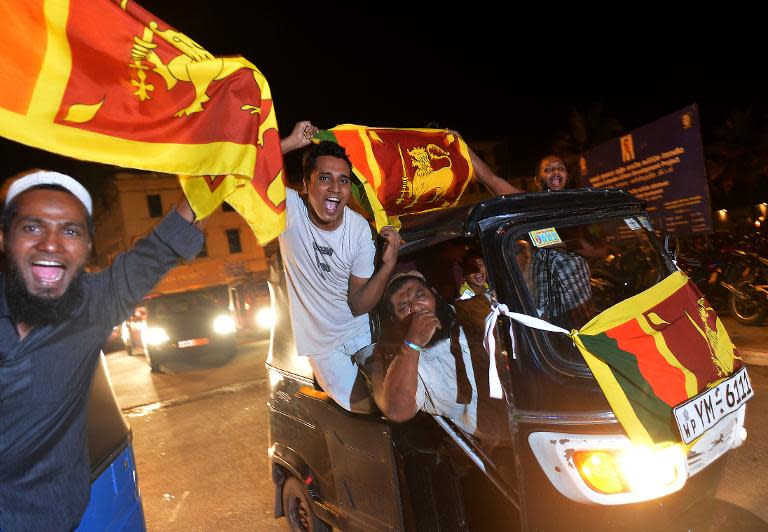 Sri Lankan cricket fans in a rickshaw wave flags as they celebrate in Colombo after Sri Lanka beat India during the final of the ICC World Twenty20 cricket match on April 6, 2014