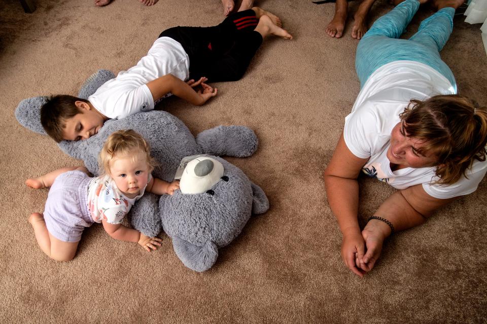 Emily Zapara, 1, her cousin, Avhustin Hrabovyk, 8, and her mother, Inna Zapara 50, rest and play, on July 1, 2022, on the living room floor of their new home in Erie. The Ukranian family of six recently came to Erie after fleeing their war-torn county. The Hrabovyk's lived in Irpin, Ukraine, and left their home on February 24, 2022, the first day of the war. The Zapara's lived in Energodar, Ukraine, and left their home on March 9, 2022. After traveling through Poland, the family reunited in Germany where they took three planes to Tiajuana, Mexico and then two additional planes to reach Erie.