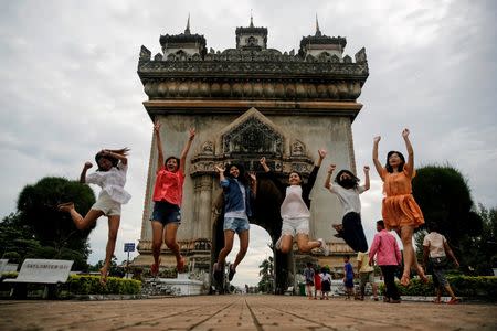 Women jump as they pose for photo in front Patuxay park, ahead of the ASEAN Summit in Vientiane, Laos September 5, 2016. REUTERS/Soe Zeya Tun