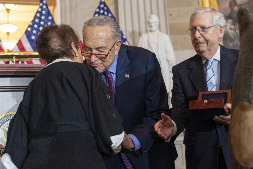 Gladys Sicknick, left, mother of slain U.S. Capitol Police Officer Brian Sicknick, is greeted by Senate Majority Leader Chuck Schumer of N.Y., with Senate Minority Leader Mitch McConnell of Ky., at right, during a Congressional Gold Medal ceremony honoring law enforcement officers who defended the U.S. Capitol on Jan. 6, 2021, in the U.S. Capitol Rotunda in Washington, Tuesday, Dec. 6, 2022. The members of the Sicknick family declined to shake hands with McConnell and House Minority Leader Kevin McCarthy of Calif. (AP Photo/Alex Brandon)