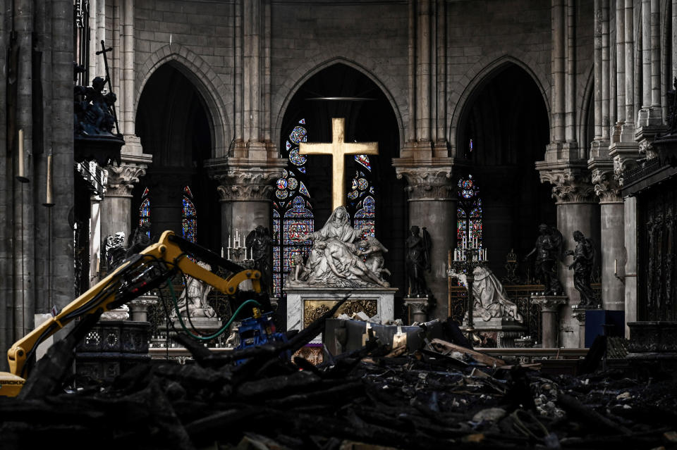 Rubble lies below the Pieta sculpture and a cross inside the Notre Dame de Paris cathedral as Canadian Prime Minister Justin Trudeau visits on Wednesday May 15, 2019 in Paris. (Philippe Lopez/Pool via AP)