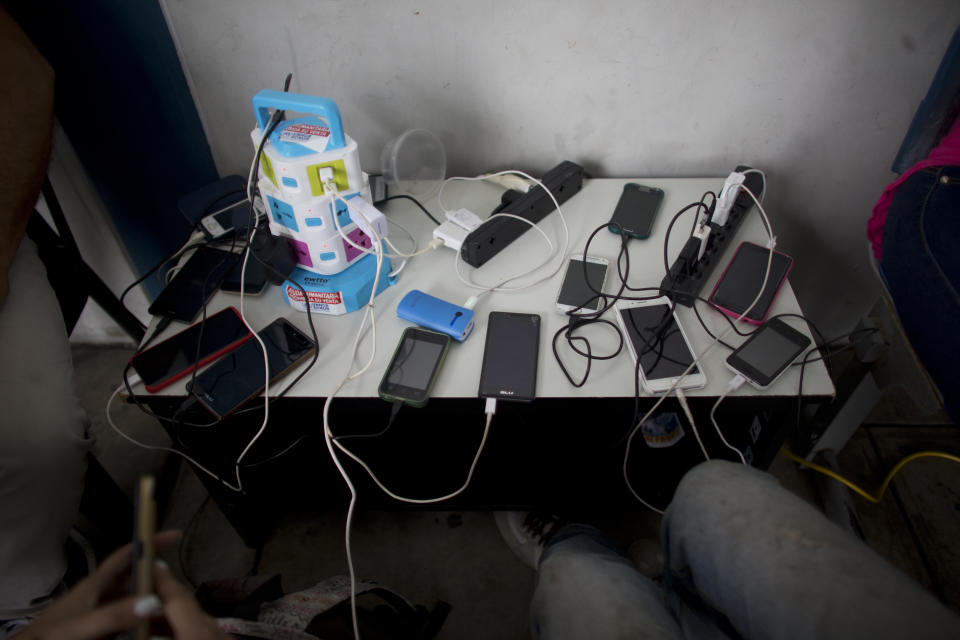 In this photo Sept. 7, 2018 photo, cellphones belonging to Venezuelans are charged for free at the immigration office in Aguas Verdes, Peru. It's not known how many reach their final destination. Facebook groups are filled with posts from Venezuelans looking for friends and family members who took off walking and disappeared. (AP Photo/Ariana Cubillos)