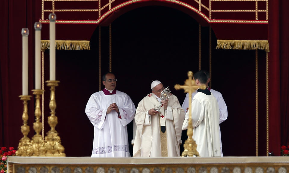 Pope Francis kisses the relic of Pope John Paul II during a solemn ceremony in St. Peter's Square at the Vatican, Sunday, April 27, 2014. Pope Francis has declared his two predecessors John XXIII and John Paul II saints in an unprecedented canonization ceremony made even more historic by the presence of retired Pope Benedict XVI. (AP Photo/Domenico Stinellis)