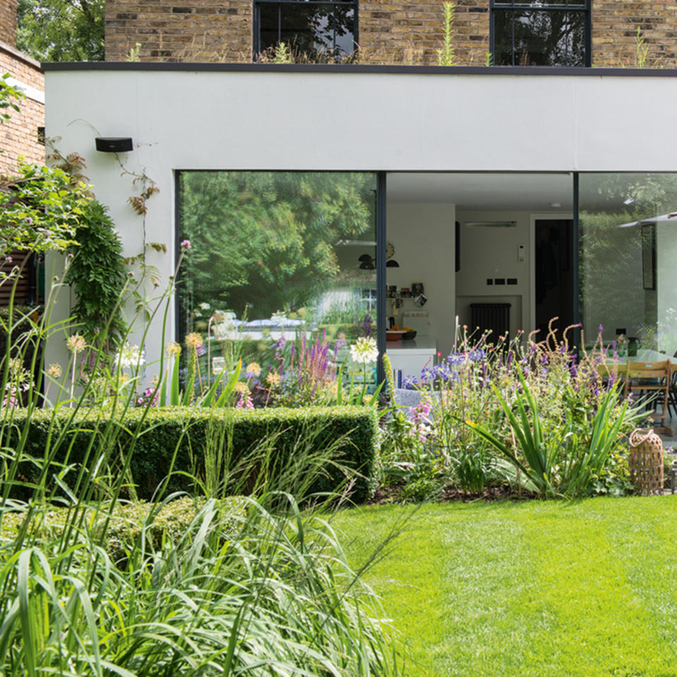 Exterior of back of house with extension, patio and lawn