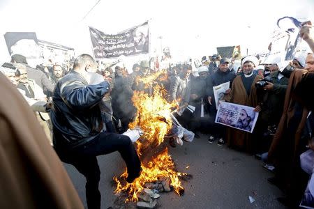 Supporters of Shi'ite cleric Moqtada al-Sadr burn an effigy of King Salman of Saudi Arabia during a demonstration against the execution of Shi'ite Muslim cleric Nimr al-Nimr in Saudi Arabia, in Baghdad, Iraq January 4, 2016. REUTERS/Thaier Al-Sudani