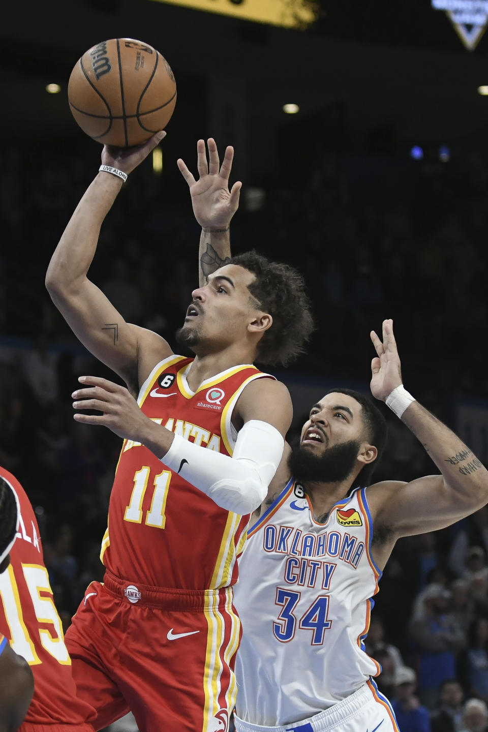 Atlanta Hawks guard Trae Young (11) goes up for a shot around Oklahoma City Thunder forward Kenrich Williams (34) in the first half of an NBA basketball game, Wednesday, Jan. 25, 2023, in Oklahoma City. (AP Photo/Kyle Phillips)