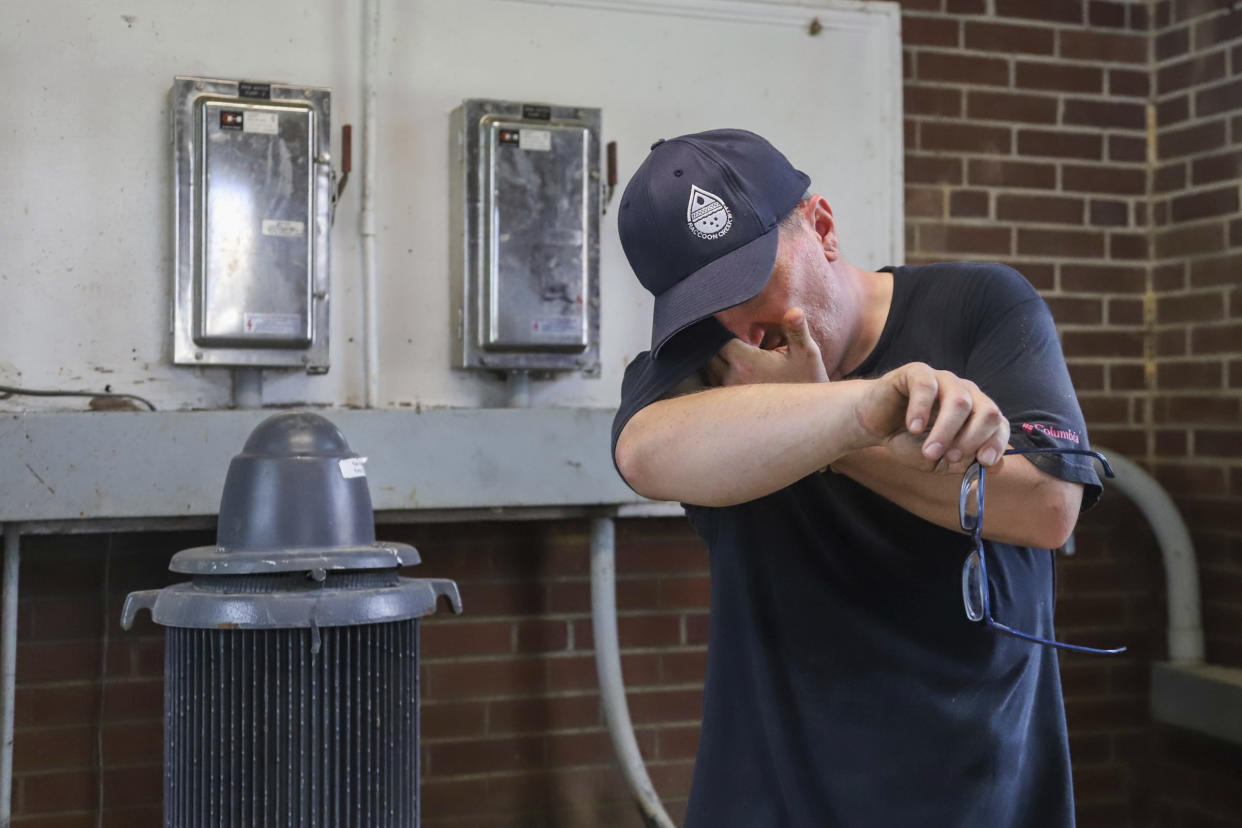 Jason Green, of the Summerville Water Treatment plant, wipes sweat from his face, Tuesday, Sept. 6, 2022, in Summerville, Ga. After flooding in Chattooga County, many residents have been left without water. (Olivia Ross/Chattanooga Times Free Press via AP)