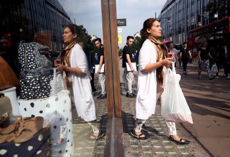 A shopper is reflected on the window of a store in London, Britain, August 25, 2016. REUTERS/Neil Hall