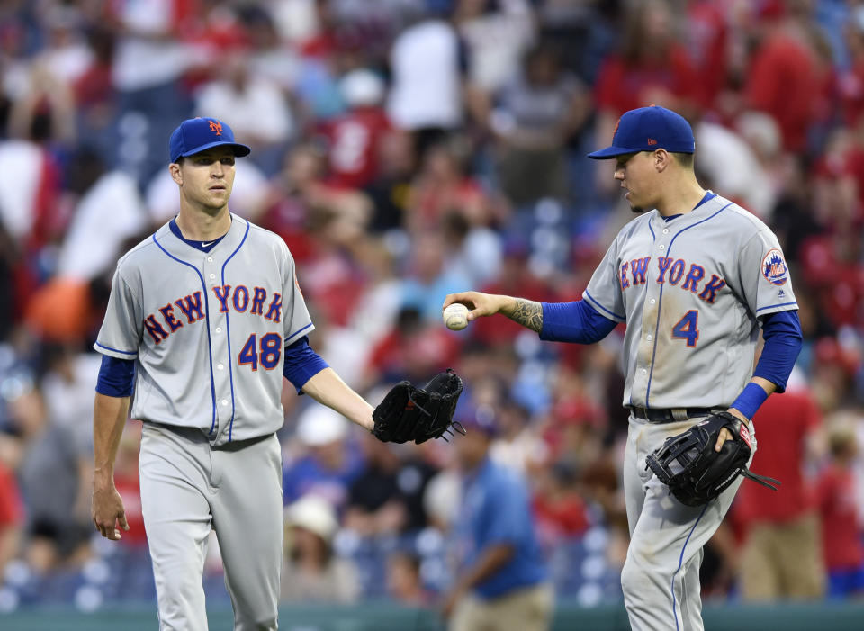 New York Mets' Wilmer Flores (4) hands the game ball to Jacob deGrom (48) at the end of the ninth inning of a baseball game against the Philadelphia Phillies, Saturday, Aug. 18, 2018, in Philadelphia. The Mets won 3-1. (AP Photo/Michael Perez)