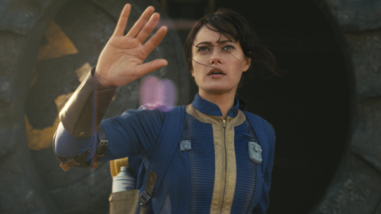  A jumpsuit-clad Lucy, played by Ella Purnell, emerges from a vault in the Fallout TV series. 