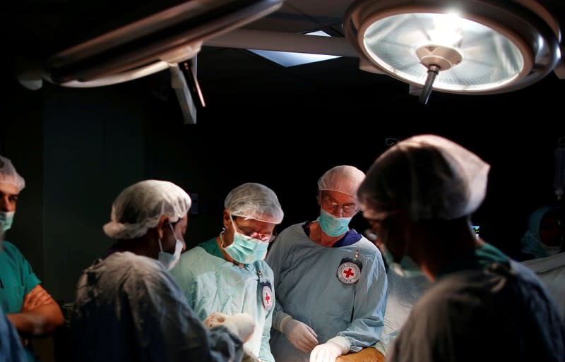 FILE PHOTO: British vascular surgeon John Wolfe, who was invited to Gaza by ICRC, performs a surgery for a wounded Palestinian in the operating room in a hospital in Gaza City