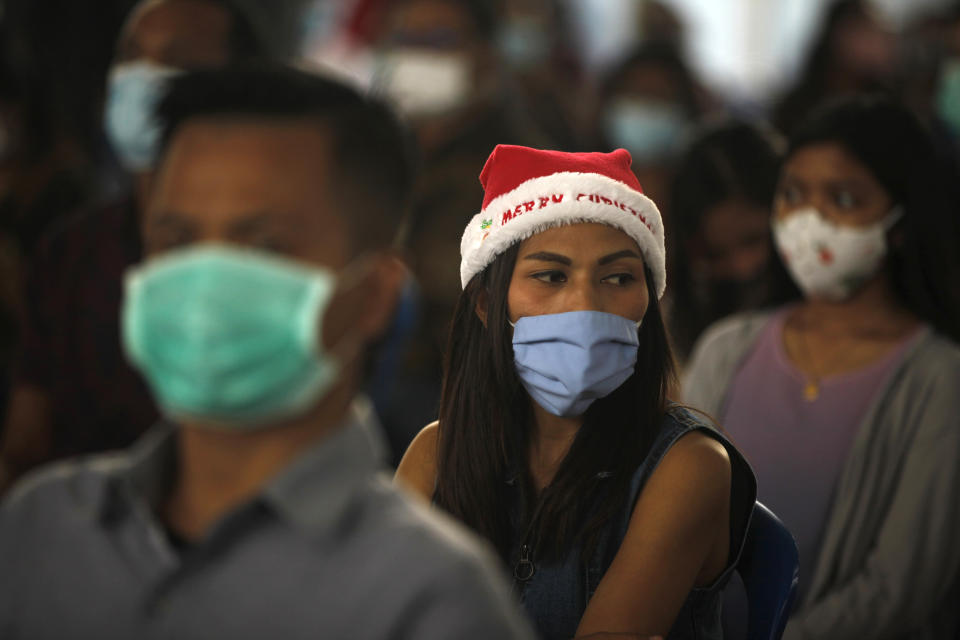 Indonesian Catholics wearing face masks to protect against coronavirus, attend a Christmas mass service at a church in Bali, Indonesia on Thursday, Dec. 24, 2020. (AP Photo/Firdia Lisnawati)