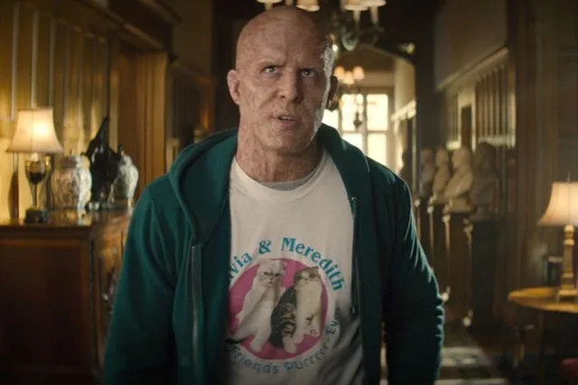 <p>Disney+</p> Ryan Reynolds wearing a Olivia and Meredith cat shirt in 'Deadpool 2.'