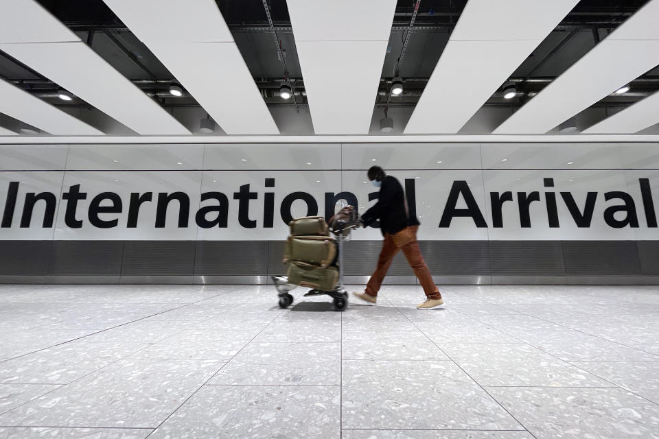 LONDON, ENGLAND - NOVEMBER 26: International passengers walk through the arrivals area at Terminal 5 at Heathrow Airport on November 26, 2021 in London, England. A heavily-mutated new variant of the Covid-19 virus, currently called B.1.1.529, has been detected in South Africa, Botswana and Hong Kong. The U.K. Health Secretary Sajid Javid said from 12:00 GMT on Friday all flights from South Africa, Namibia, Zimbabwe, Botswana, Lesotho and Eswatini are being suspended and the countries added to the UK's travel Red List. (Photo by Leon Neal/Getty Images)