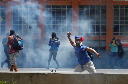 A demonstrator throws a stone towards policemen (not pictured) during an opposition rally in Caracas, Venezuela April 6, 2017. REUTERS/Carlos Garcia Rawlins