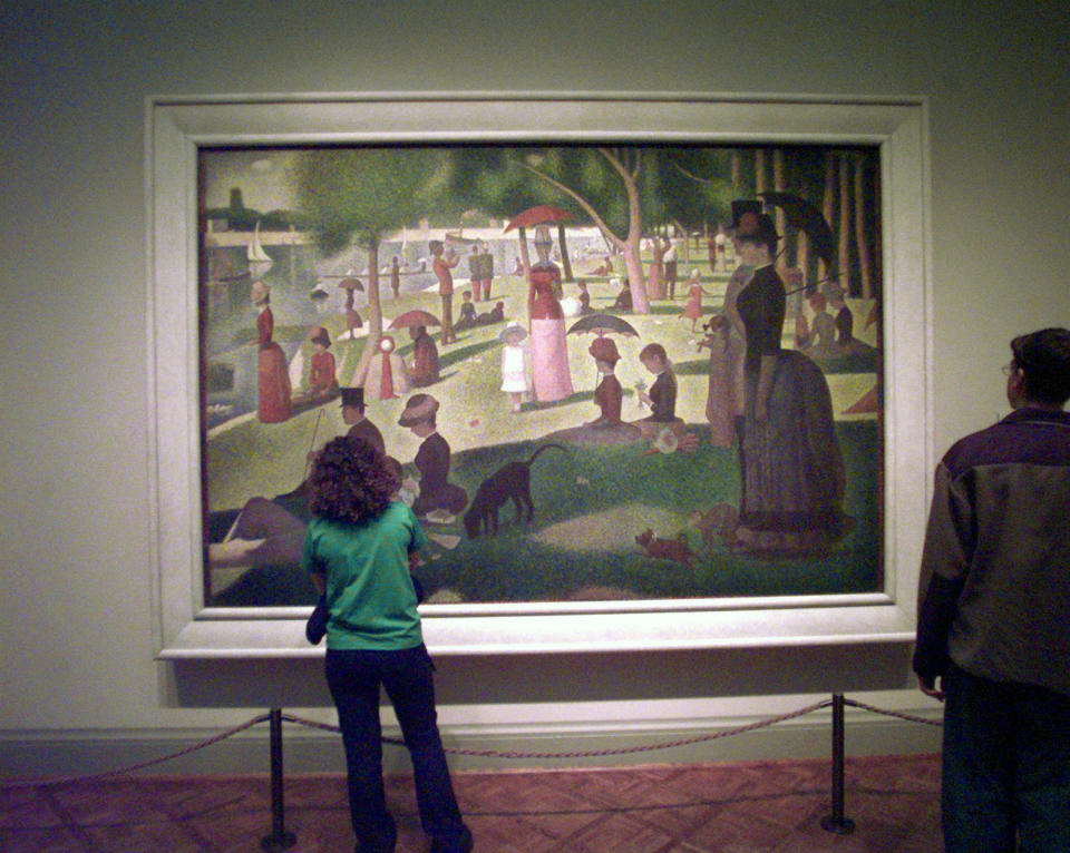 A patron takes in "A Sunday on La Grande Jatte-1884" by French Post Impressionist artist Georges Seurat at the Art Institute of Chicago, Oct. 30, 1998. The museum received two conti-crayon drawings by Seurat that were done as a figure study for his famous painting. The drawings came from the Museum of Modern Art in New York which had to give away four impressionist artworks valued at more than $40 million because the patron who bequeathed them at her death in 1948 believed they would no longer be "modern" after 50 years.  (AP Photo/Charles Bennett)