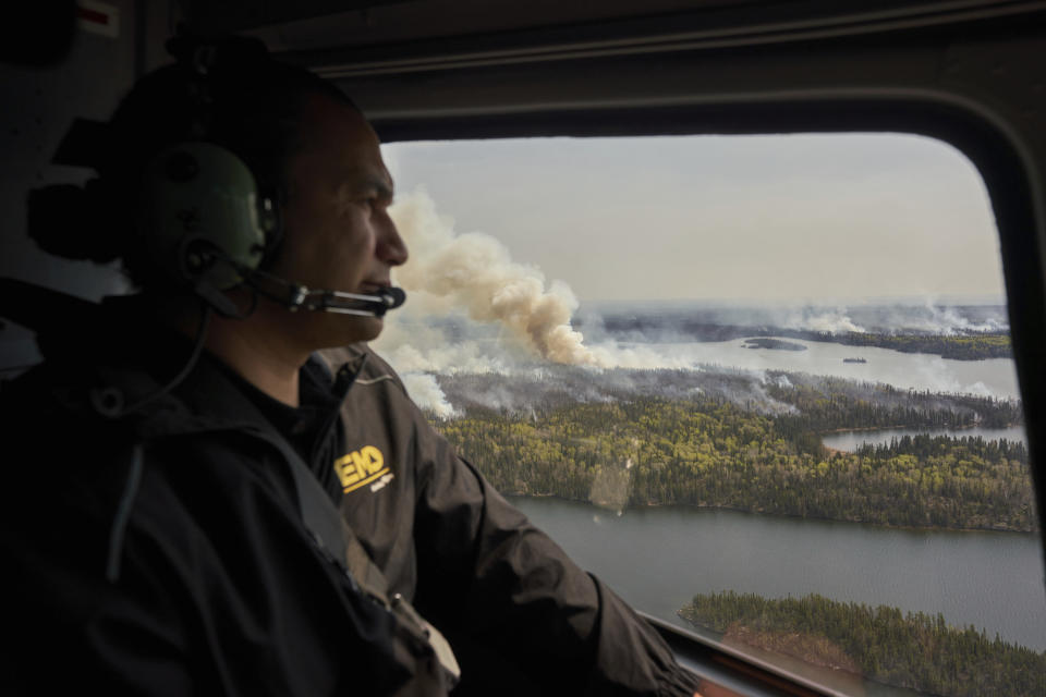 Manitoba Premier Wab Kinew surveys wildfires burning in northern Manitoba from a helicopter on Tuesday, May 14, 2024. (David Lipnowski/The Canadian Press via AP)