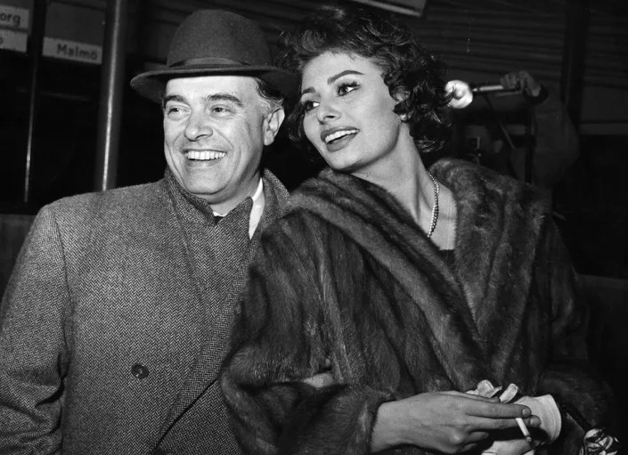 Carlo Ponti, el director de cine italiano y su esposa Sophia Loren, la actriz de cine que llegan a Copenhague en ruta de Roma a Los Ángeles. Se negaron a comentar sobre el rumor de que Sophia estaba esperando un bebé. (Foto de Keystone/Getty Images)