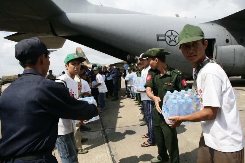 Myanma service members form a line to unload water supplies from a U.S. Air Force C-130 Hercules aircraft at Rangoon International Airport in Myanmar on May 12, 2008. The shipment of water, mosquito nets and blankets arrived on the first of three planned relief flights to provide aid to citizens devastated by Tropical Cyclone Nargis. File Photo by Andres Alcaraz/U.S. Marine Corps