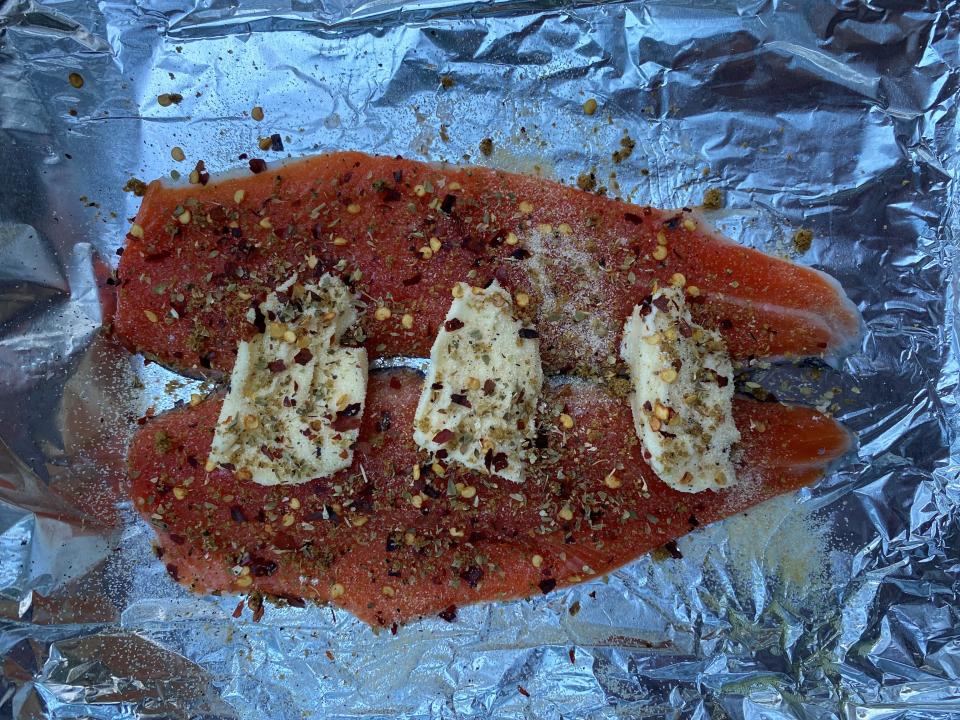 Two seasoned kokanee filets in a tin foil wrapping.