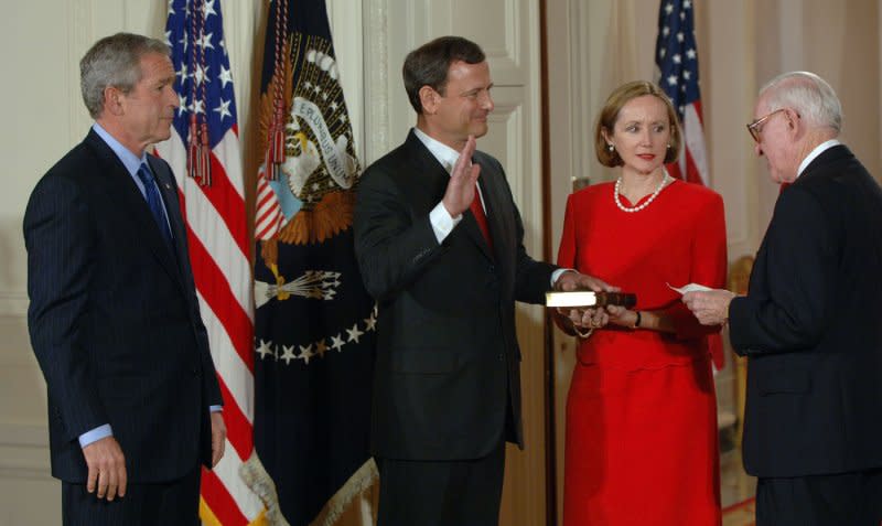 Judge John Roberts (2nd L) is sworn in by Supreme Court Justice John Paul Stevens (R) as his wife, Jane Roberts, holds the Bible and U.S. President George W. Bush watches on September 29, 2005, in the East Room of the White House. File Photo by Roger L. Wollenberg/UPI