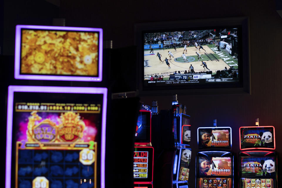 A basketball game on a TV screens seen among electronic betting machines at Turfway Park Racing & Gaming, Friday, Dec. 22, 2023, in Florence, Ky. Sports betting has spread rapidly across U.S. states in the past five years. But the odds for further expansion may be fading as state legislatures prepare to return to work in 2024. (AP Photo/Carolyn Kaster)