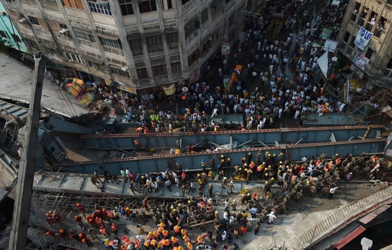 <p>Indian rescue workers and volunteers try to free people trapped under the wreckage of a collapsed flyover bridge in Kolkata on March 31, 2016. At least 14 people were killed and dozens more injured when a flyover collapsed in a busy Indian city on March 31, an official said, as emergency workers battled to rescue people trapped under the rubble. </p>