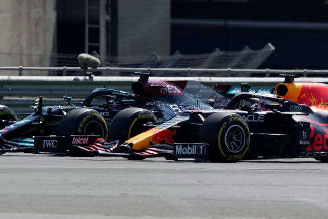 Lewis Hamilton (left) and Max Verstappen take a curve side by side at the start of the race