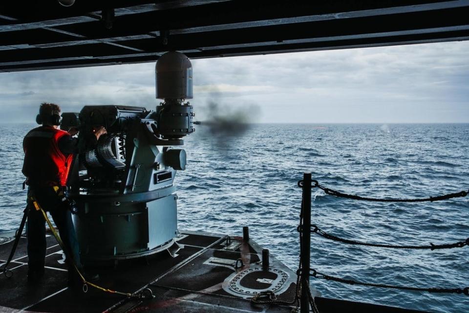 A Gunner's Mate aboard Nimitz-class aircraft carrier USS George Washington (CVN 73) fires an MK-38 25mm gun mount.