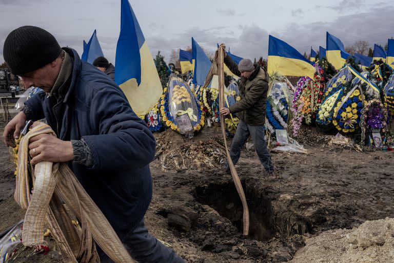 Los trabajadores del cementerio entierran el ataúd de Oleksiy Lytvynov, un soldado ucraniano, durante su funeral en Boryspil, cerca de Kiev, Ucrania, el domingo 19 de febrero de 2023