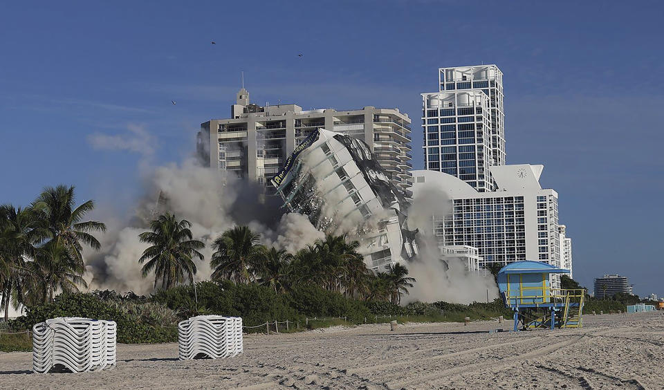 On Sunday, Nov. 13, 2022 Miami Beach's 17-story hotel tower of the historic Deauville Beach Resort implodes sending dust full of debris into the oceanside luxury buildings. (Carl Juste/Miami Herald via AP)