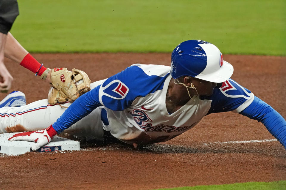 Atlanta Braves' Cristian Pache (25) advances to third base on a Ronald Acuna Jr. fly ball in the fifth inning of a baseball game against the Philadelphia Phillies, Saturday, April 10, 2021, in Atlanta. (AP Photo/John Bazemore)