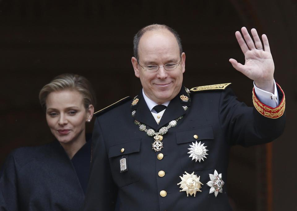 Prince Albert II of Monaco and his wife Princess Charlene wave from the Palace balcony during Monaco's National Day