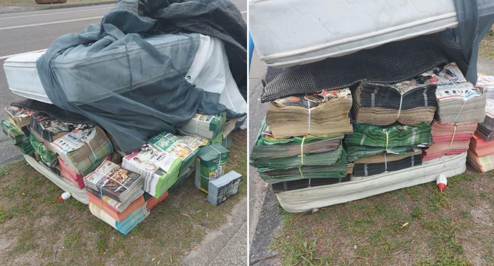 Dumped stacks of catalogues sit on the side of the road beneath mattress.