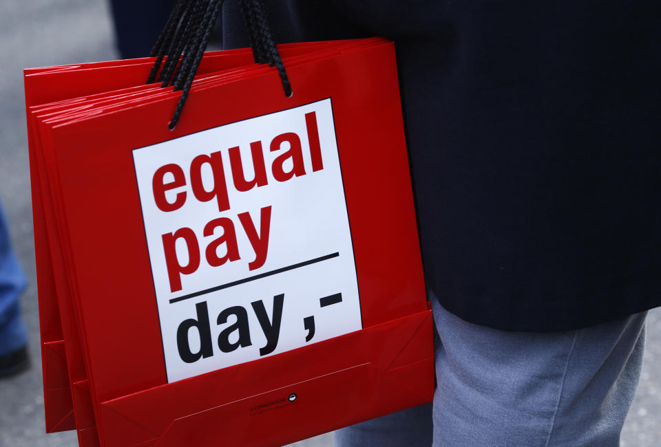 People carry bags reading 'equal pay day' during a protest a day before International Women's Day, in Bern March 7, 2015.  REUTERS/Ruben Sprich