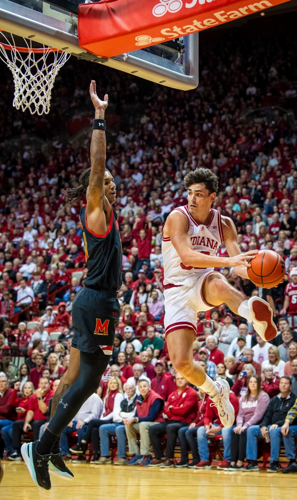 Indiana University's Trey Galloway (32) passes around Maryland's Julian Reese (10) during the first half of the Indiana versus Maryland men's basketball game at Simon Skjodt Assembly Hall on Friday, Dec. 1, 2023.