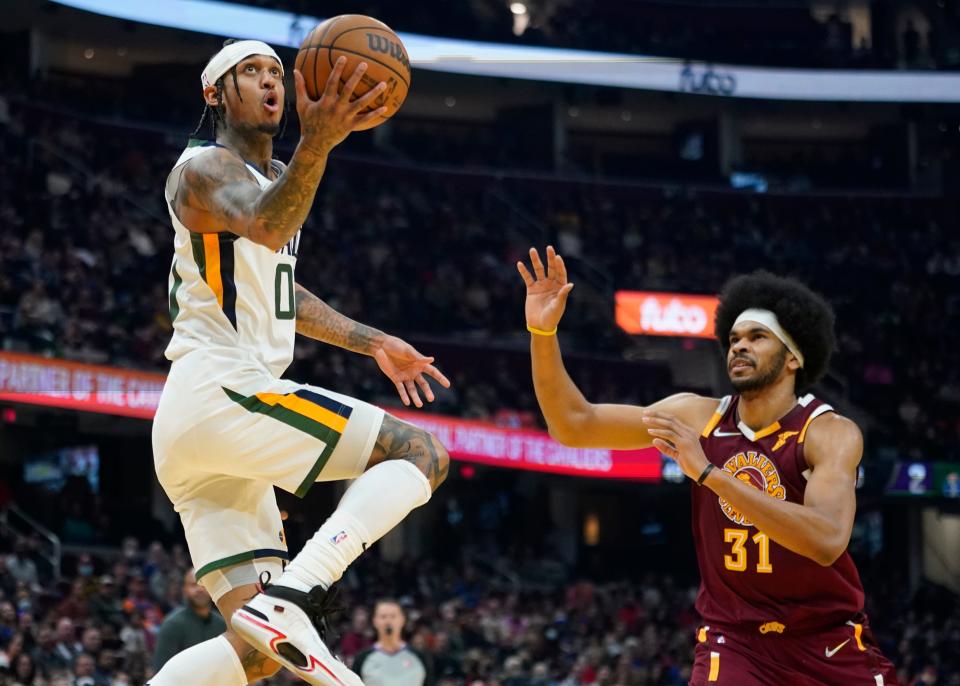 Utah Jazz's Jordan Clarkson (00) drives to the basket against Cleveland Cavaliers' Jarrett Allen (31) in the first half of an NBA basketball game, Sunday, Dec. 5, 2021, in Cleveland. (AP Photo/Tony Dejak)