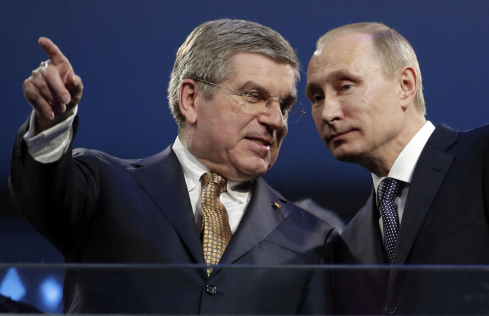 FILE - International Olympic Committee President Thomas Bach, left, and Russian President Vladimir Putin watch the closing ceremony of the 2014 Winter Olympics, on Sunday, Feb. 23, 2014, in Sochi, Russia. Putin launched the Sochi Games to enhance Russia’s image. (AP Photo/Charlie Riedel, File)