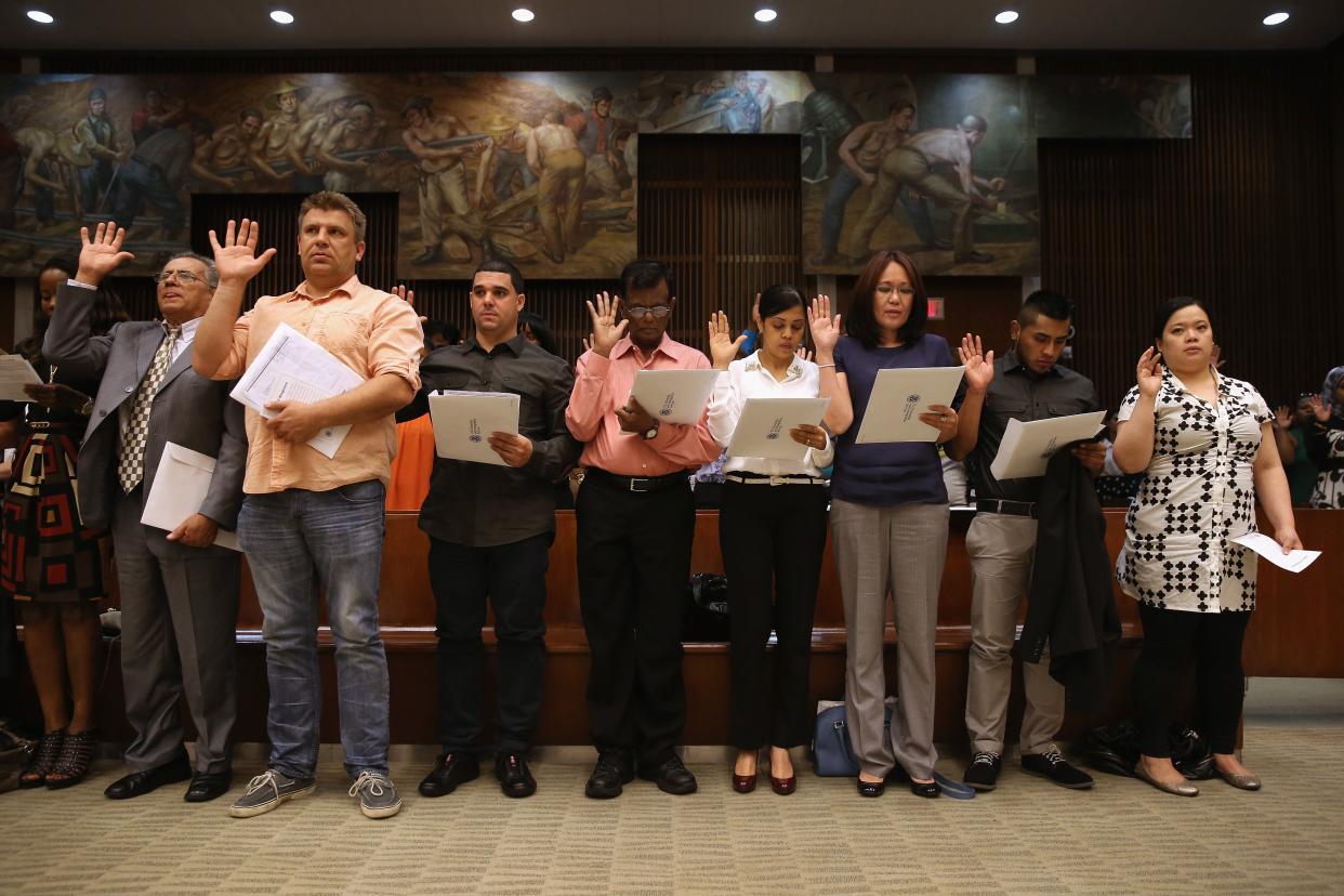 Immigrants take the oath of allegiance during a citizenship ceremony in New York City in 2013 in front of Edward Laning's mural, "The Role of the Immigrant in the Industrial Development of America," which was painted as part of New Deal jobs programs in 1937. (Photo: John Moore via Getty Images)