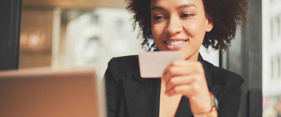 Mixed race woman in coffee shop using credit card for paying