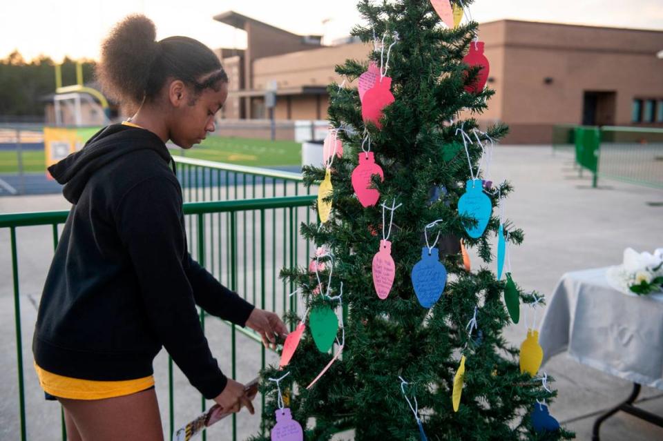 Students place notes on a Christmas tree during a candlelight vigil in honor of three Gautier High School graduates, Se’Dhari Saniya Watson-Person, Kyla “Muffin” Watkins, and Tatyanna Richmond who were involved in a fatal crash, at Gautier High School in Gautier on Thursday, Dec. 7, 2023. Watson-Person and Watkins were killed in the crash.