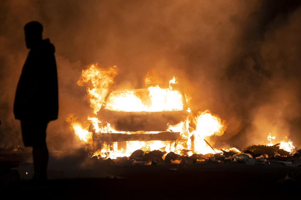 CARDIFF, WALES - MAY 23: An automobile burns on Highmead Road during unrest following a serious road crash earlier on Snowden Road on May 23, 2023 in Cardiff, Wales. Riot Police with dogs are trying to contain a large group of people causing serious disorder in Ely, Cardiff tonight. Fires have been started and missiles thrown at police after they attended a serious road traffic collision earlier in the evening. (Photo by Matthew Horwood/Getty Images)