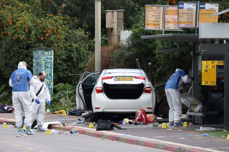 Israeli emergency personnel work next to a damaged car following a ramming attack in Ra'anana. An Israeli woman was killed, and 18 people were injured in a ramming and stabbing attack in the Israeli city of Ra'anana. Oren Ziv/dpa
