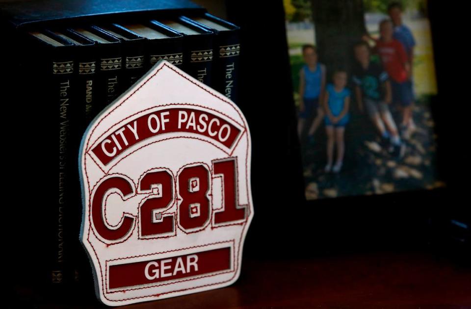 Helmet patch for Pasco Fire Chief Bob Gear sits neat to a photo of his grandchildren on the desk in his office at station 84 on West Court Street Road. Gear is retiring at the end of May, 2023.