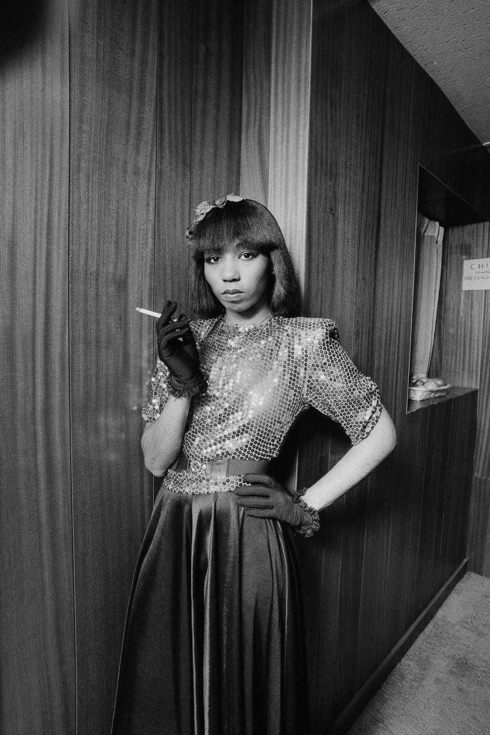 <p>Chic's Luci Martin poses backstage in 1979. The singer wears a very disco era ensemble, while smoking a cigarette. </p>