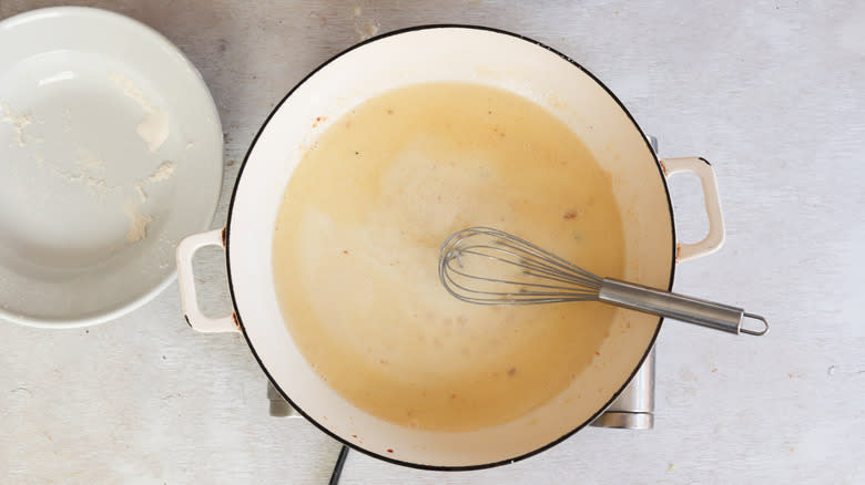 cream sauce with whisk in pan