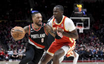 Portland Trail Blazers guard Damian Lillard, left, drives to the basket on Atlanta Hawks center Clint Capela, right, during the second half of an NBA basketball game in Portland, Ore., Monday, Jan. 30, 2023. The Blazers won 129-125. (AP Photo/Steve Dykes)