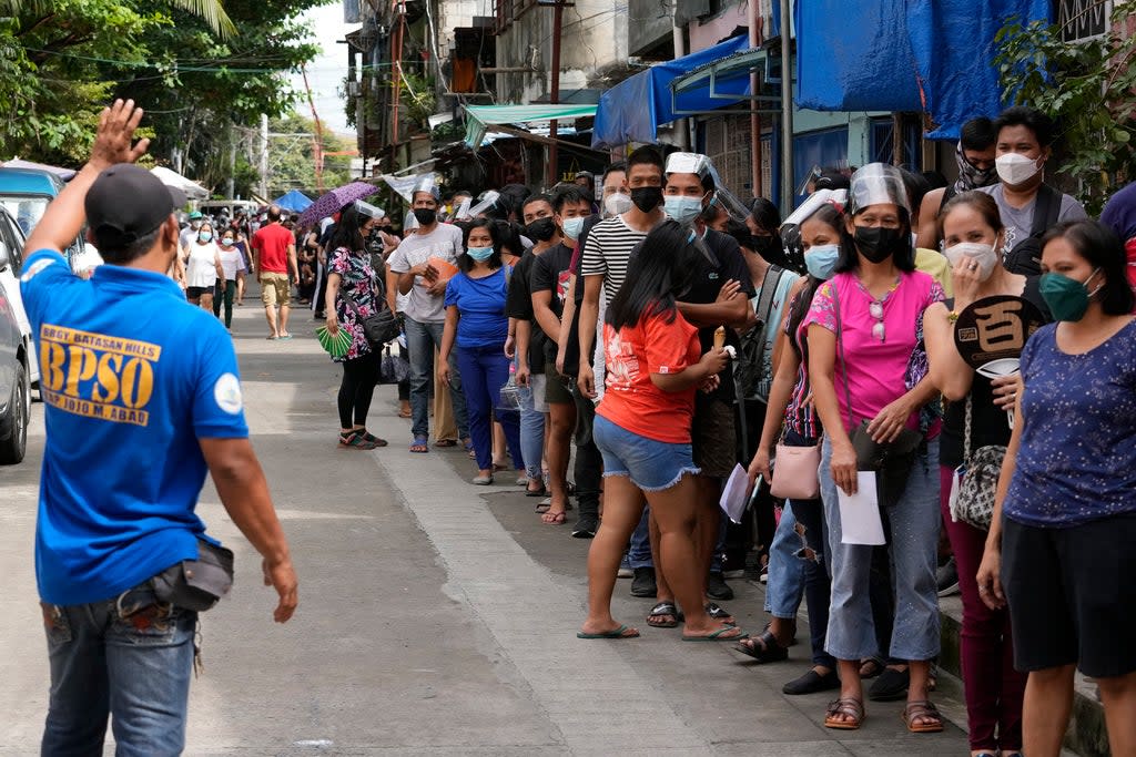People in Quezon city wait for Covid-19 vaccines during a nationwide three-day vaccination drive (AP)