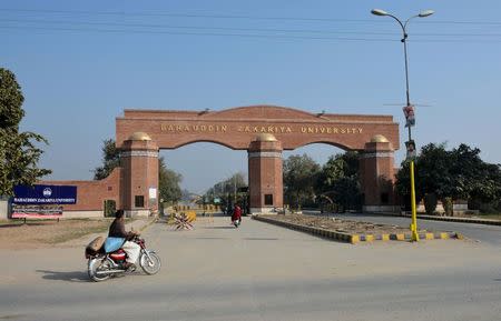 A man rides a motorcycle past the main gate of the Bahauddin Zakariya University, where Tashfeen Malik studied, in Multan, Pakistan, December 5, 2015. REUTERS/Stringer